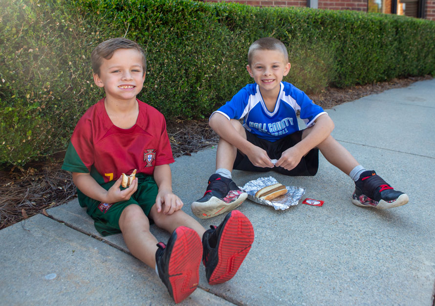 Elementary Boys sitting on sidewalk